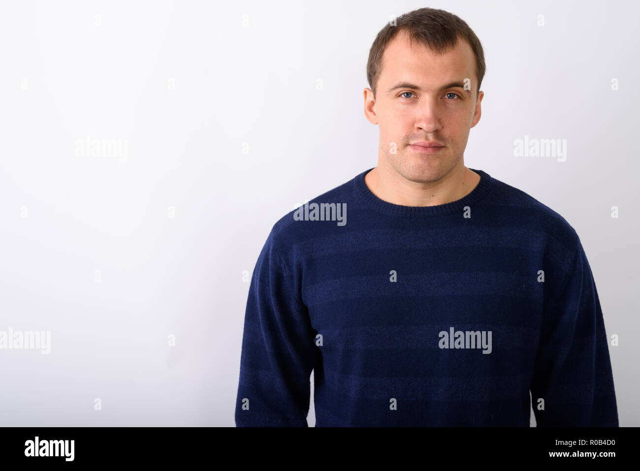 Chiusura del giovane uomo muscolare contro uno sfondo bianco Foto Stock