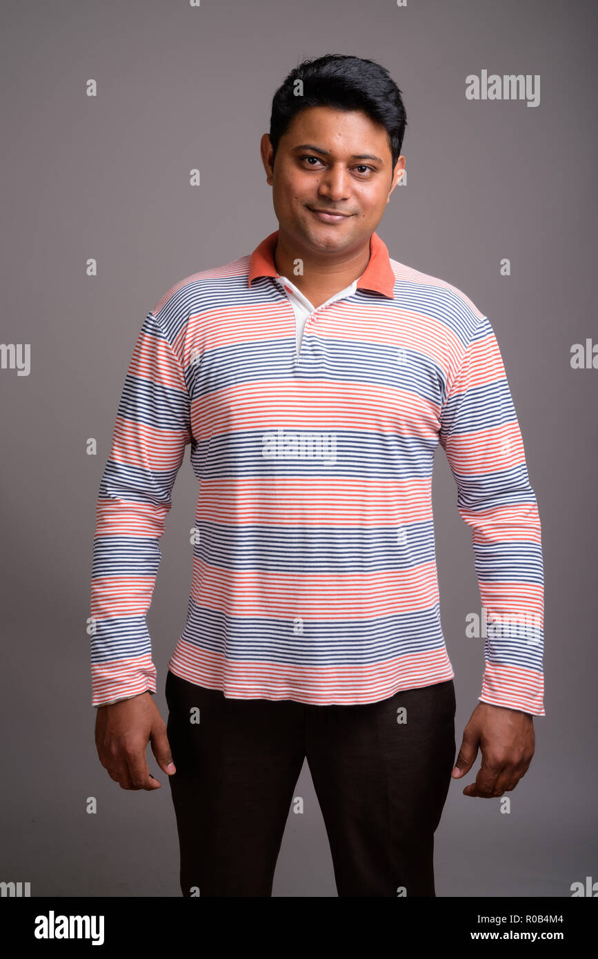 Ritratto di giovane uomo indiano contro lo sfondo grigio Foto Stock