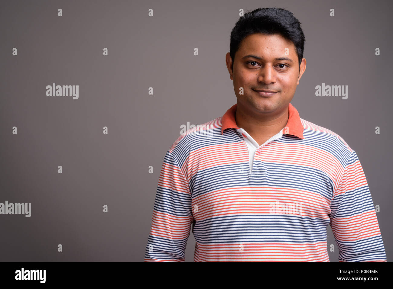 Ritratto di giovane uomo indiano contro lo sfondo grigio Foto Stock