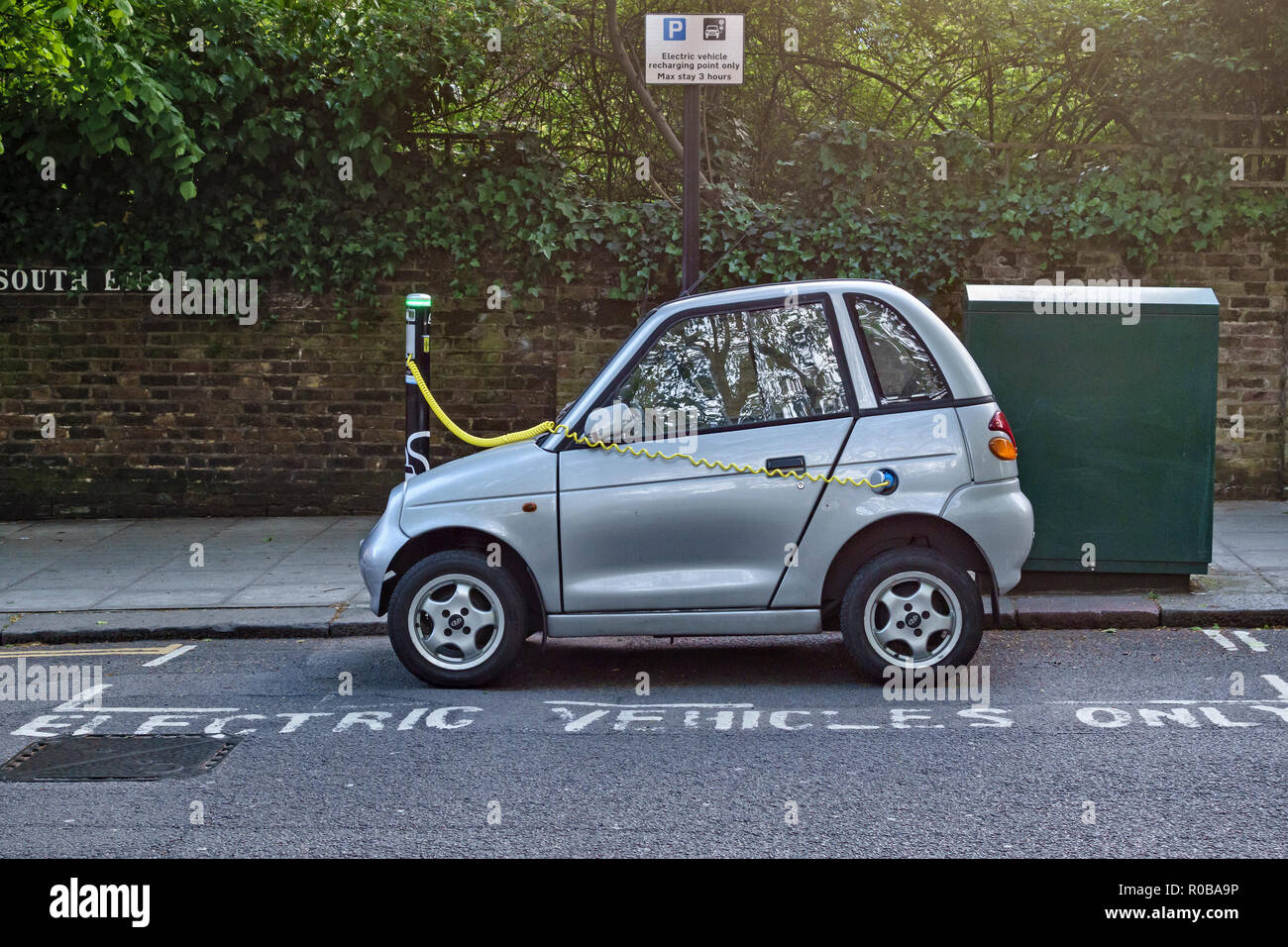 Hampstead, Londra, Regno Unito. Un G-Wiz micro auto elettrica in corrispondenza di un marciapiede punto di ricarica in un alloggiamento contrassegnato Foto Stock