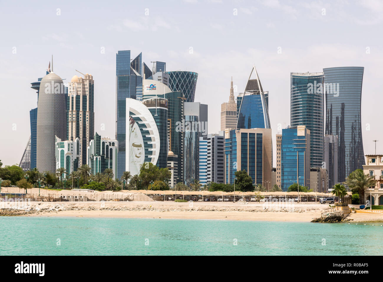 Lo skyline di Doha, in Qatar. Ricco e moderno centro città orientale di grattacieli, vista in buone condizioni meteorologiche, a mezzogiorno, durante le calde estate secca, con vista della spiaggia. Foto Stock