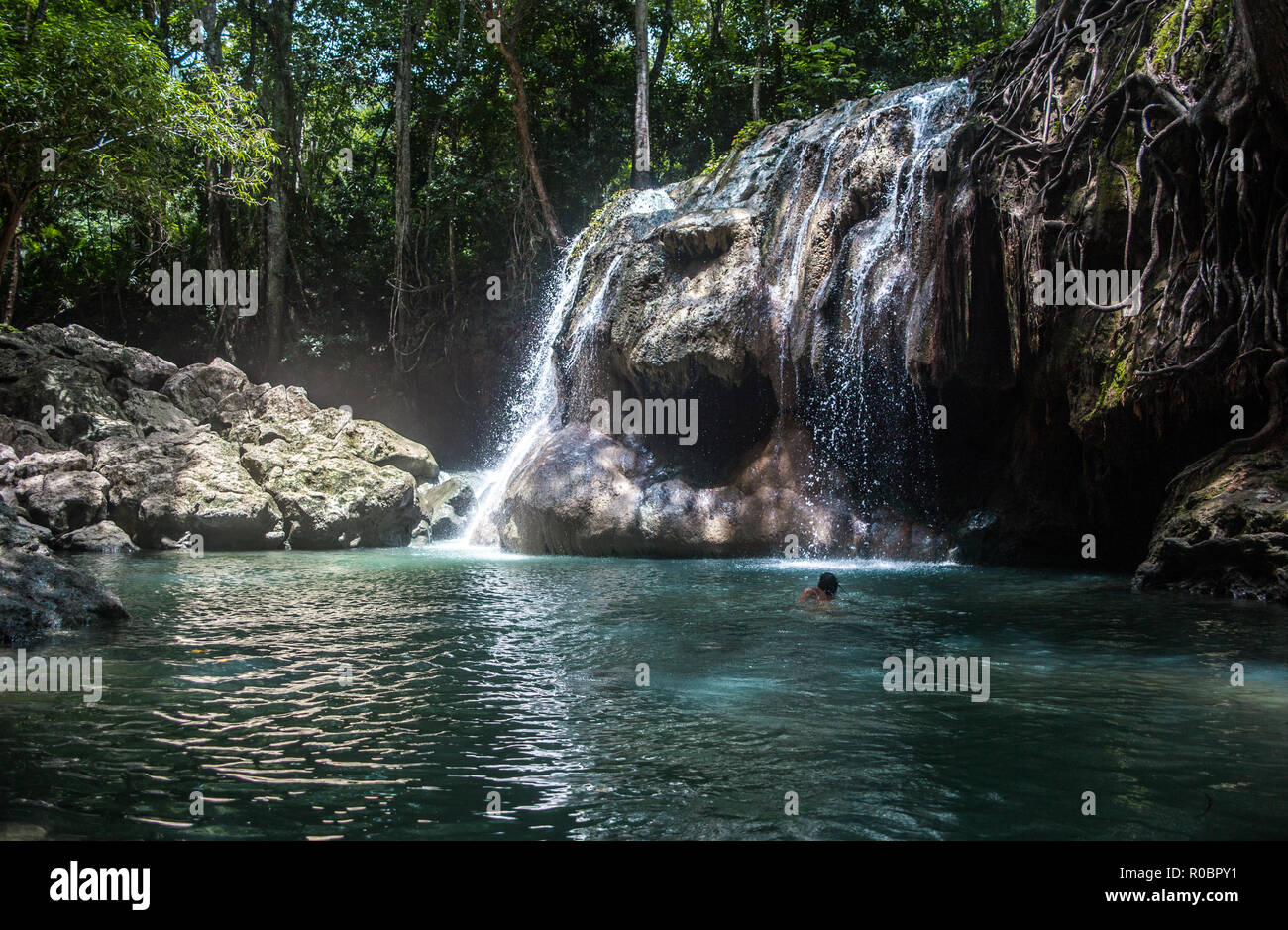 Tourist nuota nella Finca Paraiso, un insolito cascata alimentato da sorgenti calde in un gelido turchese della piscina di acqua dolce in seguito in Oriente Guatemala Foto Stock