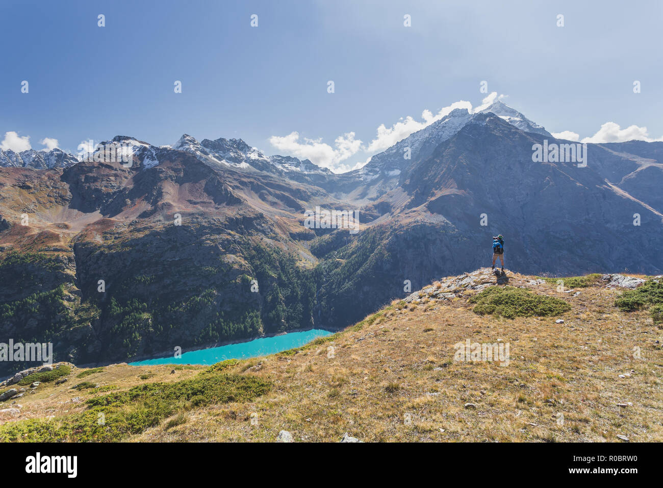 Un uomo di scattare una foto del lago di Place Moulin serbatoio glaciale, Valle d'Aosta, Alpi Italiane, Italia, Europa Foto Stock