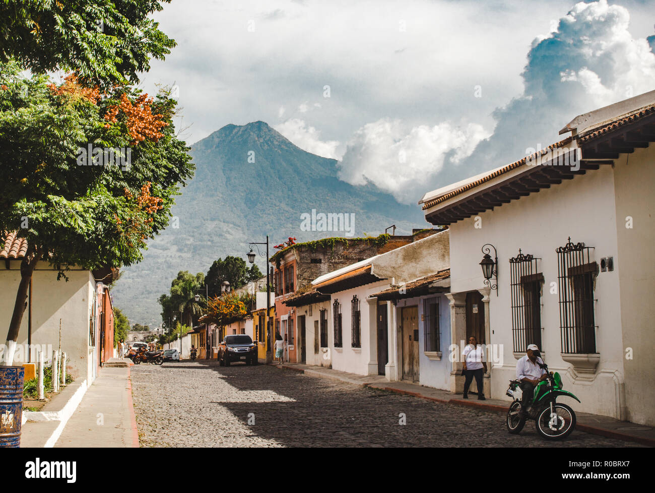 Tipica strada di ciottoli in Antigua Guatemala durante una giornata di sole - Volcan Agua vulcano sovrasta lo stile coloniale case Foto Stock