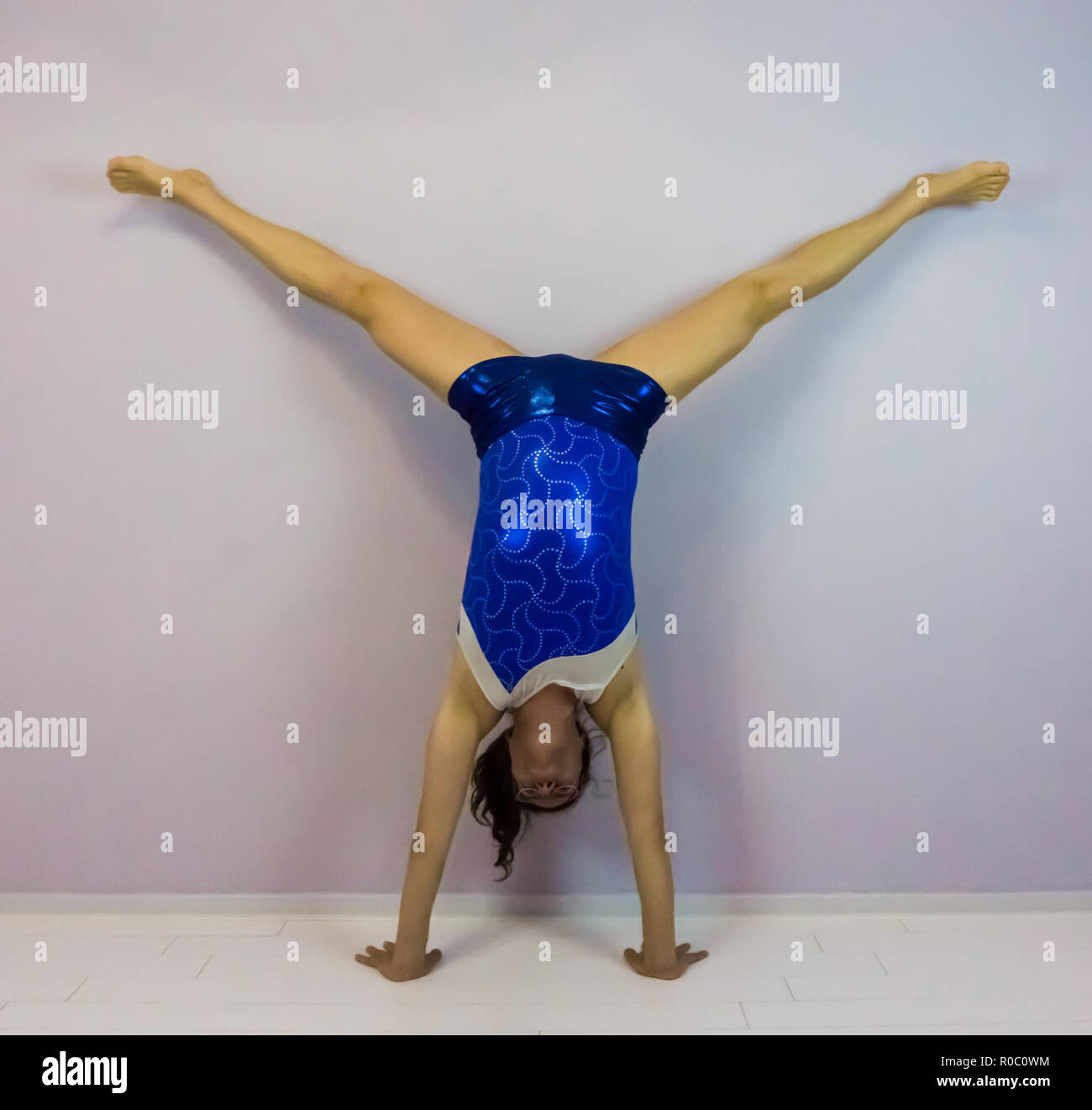 Ginnastica acrobatica a medio split handstand preformato per una giovane  ragazza transgender indossando un blu brillante body Foto stock - Alamy