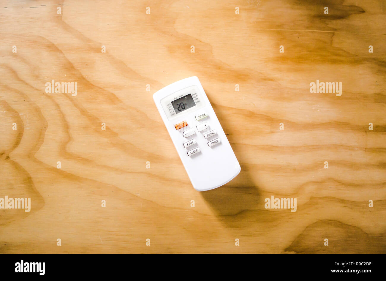 Ufficio di controllo remoto per temperatura ambiente / unità aria condizionata su una scrivania in legno Foto Stock