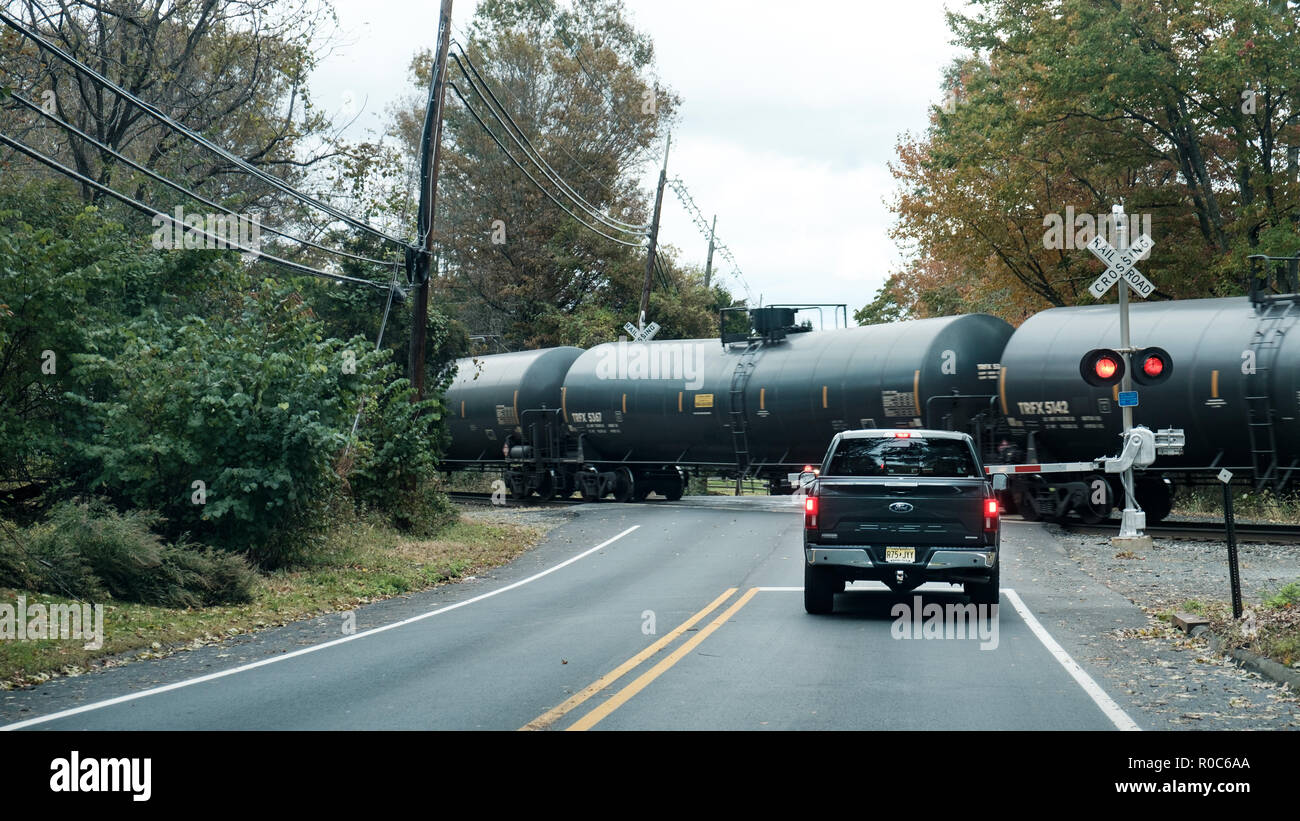 New Jersey, USA: Un veicolo si ferma su un passaggio ferroviario stradale controllato da semafori automatico, o su un passaggio in piano per consentire il passaggio di un treno merci. Foto Stock
