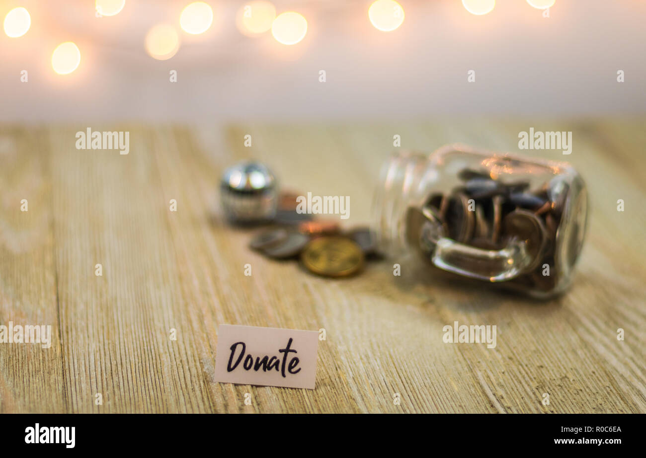 Donare denaro jar risparmi concetto motivazionale sul pannello di legno Foto Stock