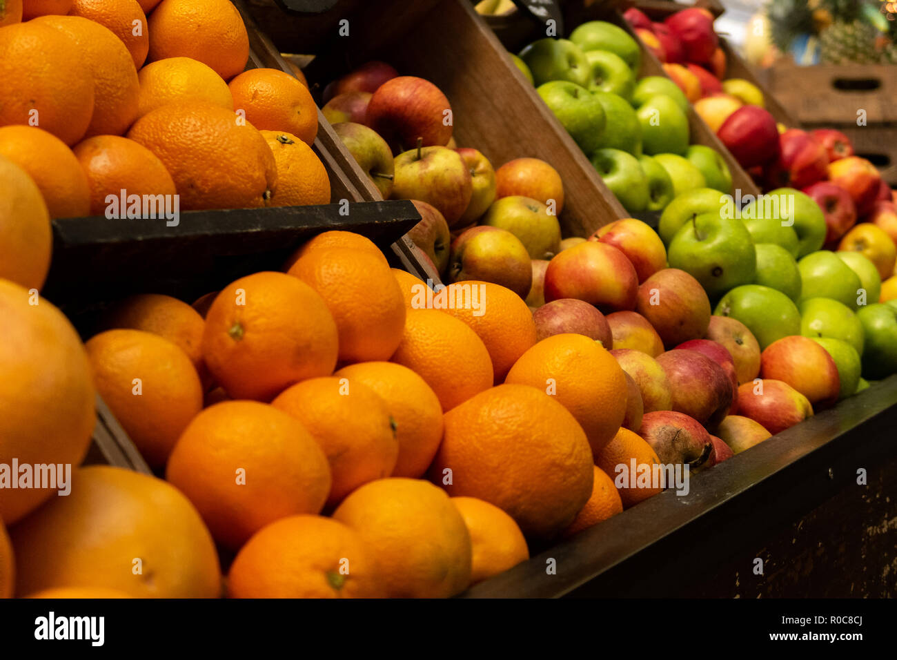 Arance e mele in vendita presso un negozio di generi alimentari in stallo in London Borough Market Foto Stock