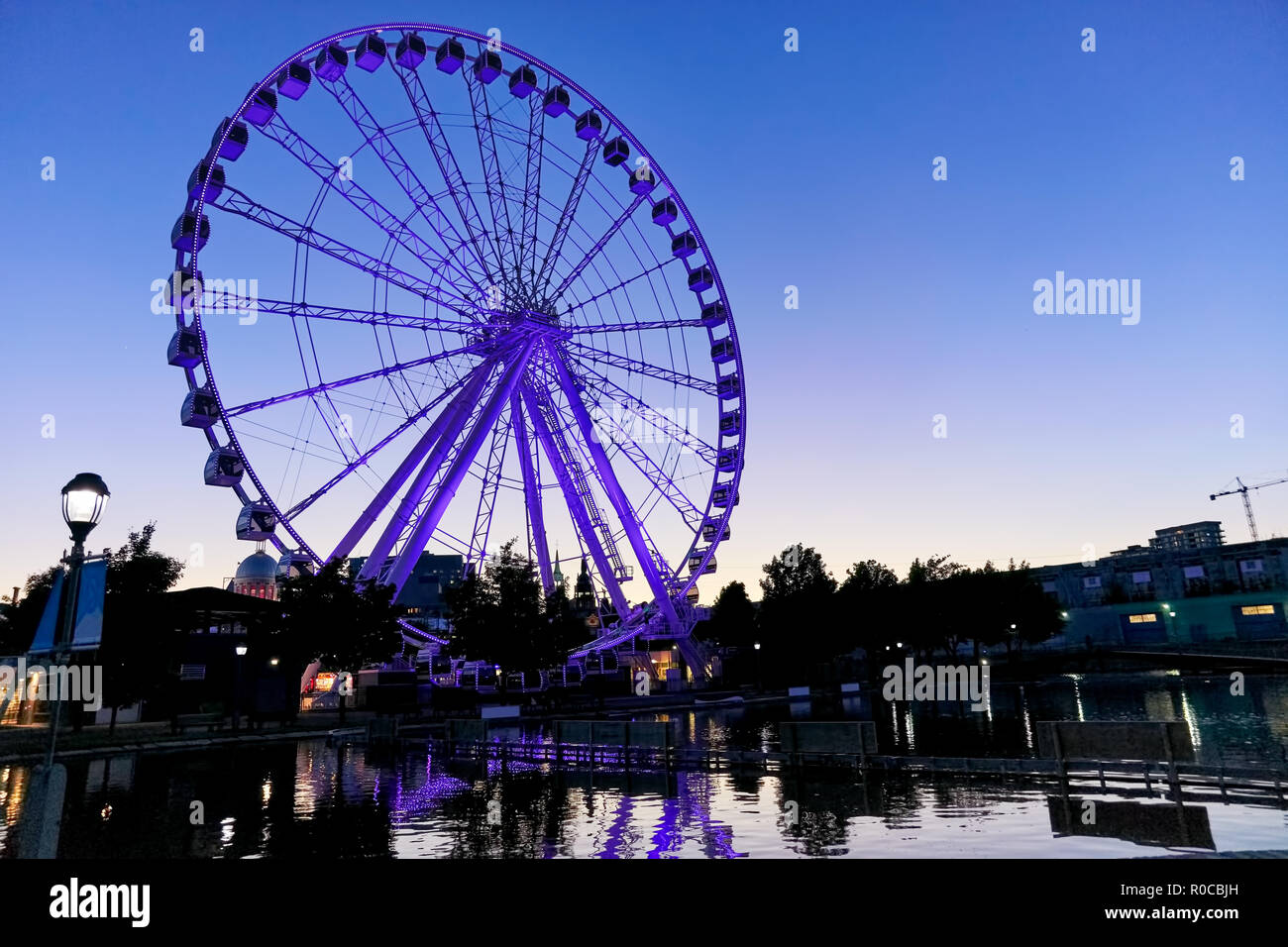 Illuminata ruota panoramica Ferris (osservazione ruota) nel vecchio porto al blue ora di una serata estiva in Montreal, Quebec, Canada Foto Stock