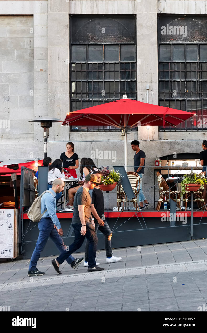 La gente che camminava per strada e seduta in un cafe' all'aperto nel vecchio porto di Montreal, Quebec, Canada. Uso editoriale. Foto Stock