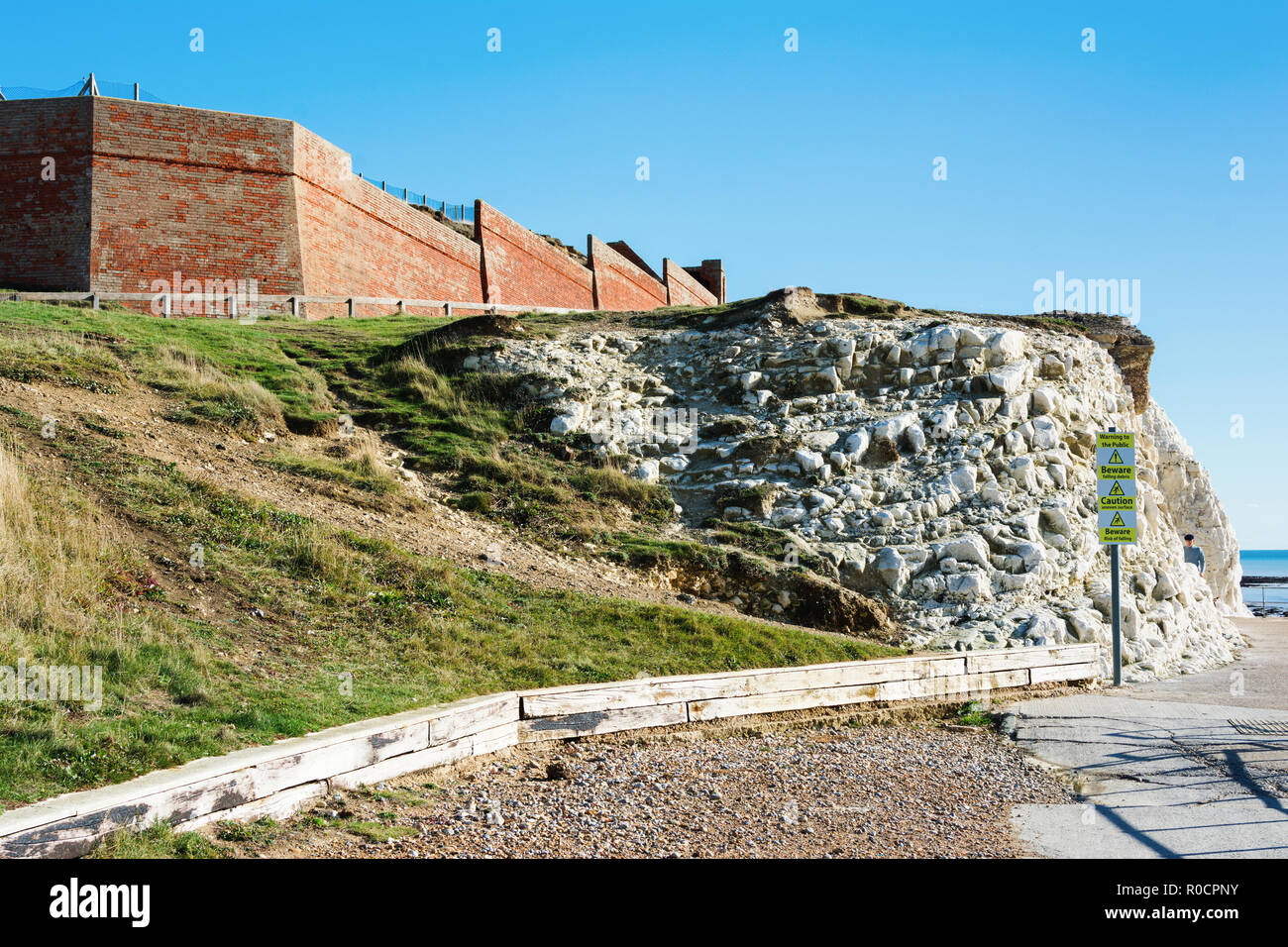 A piedi per il punto iniziale in Seaford East Sussex. Inghilterra, scogliere, il mare e il cielo blu, la vista dei resti del Cliff Cottage o Splash point hotel, il fuoco selettivo Foto Stock