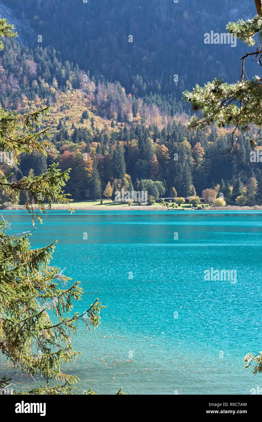 Vista sul lago color turchese "Alpsee" e sull'Alpseebad da un sentiero intorno al lago in autunno. Schwangau, Füssen, Baviera, Germania Foto Stock