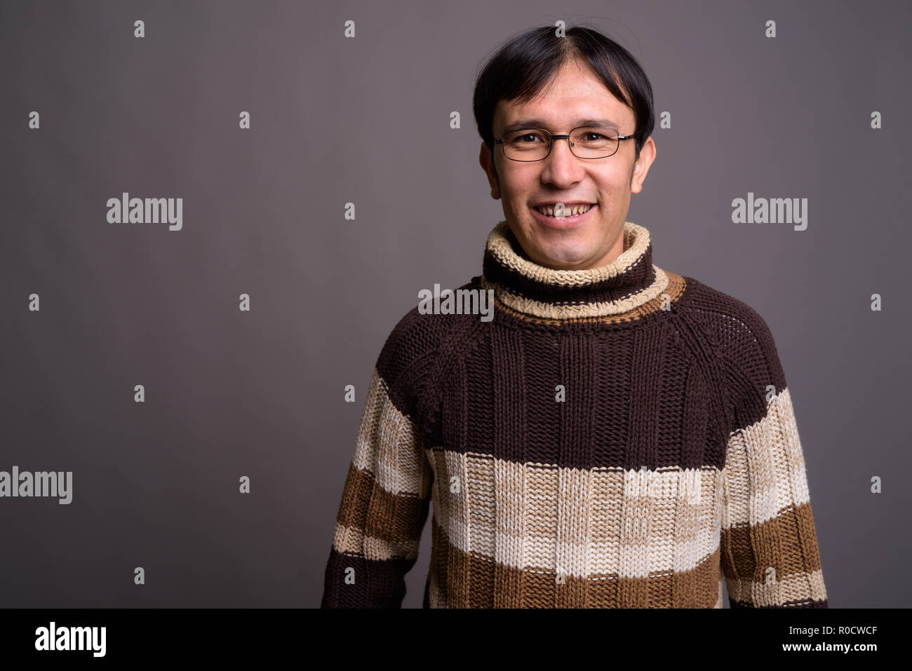 Giovani asiatici nerd uomo turtleneck indossa un maglione grigio contro bac  Foto stock - Alamy