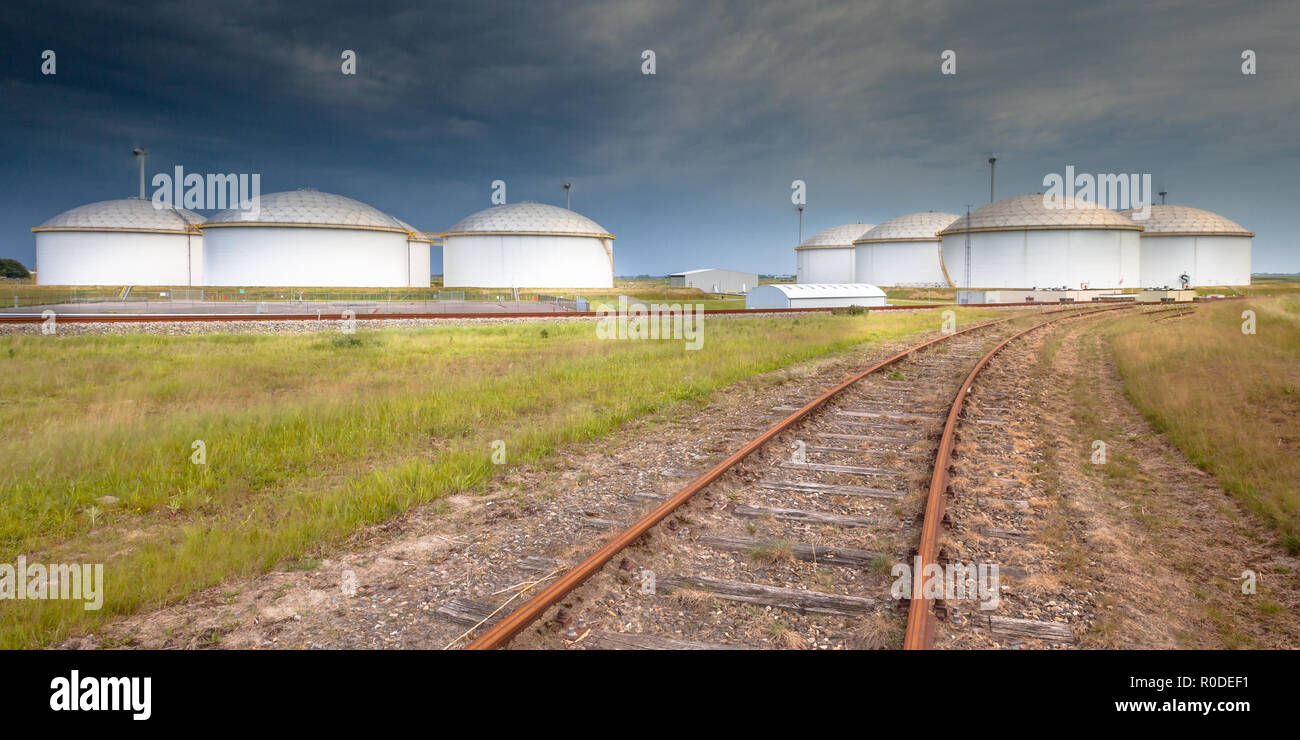 Panorama di una ferrovia che conduce a un enorme strategico serbatoio carburante morsetto di storage in un grande porto in Europa Foto Stock