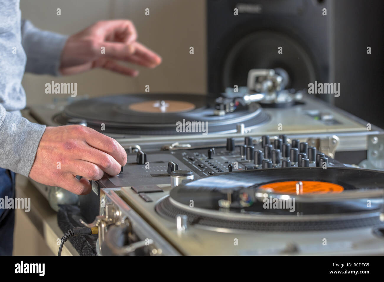 Mani di DJ di musica di miscelazione da vintage long play record nel suo studio a casa Foto Stock