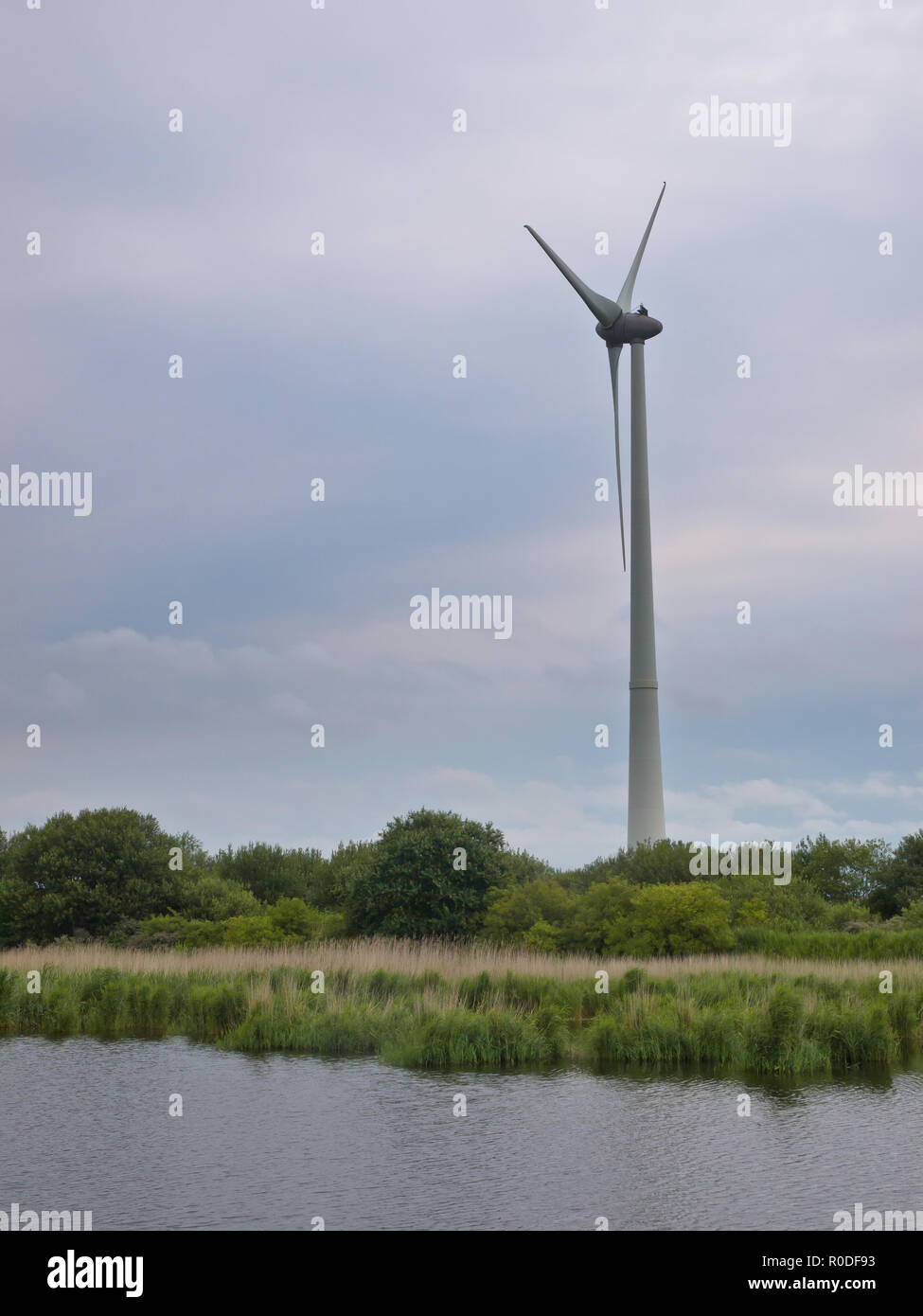 Turbina eolica la produzione di energia alternativa sul bordo di un lago Foto Stock