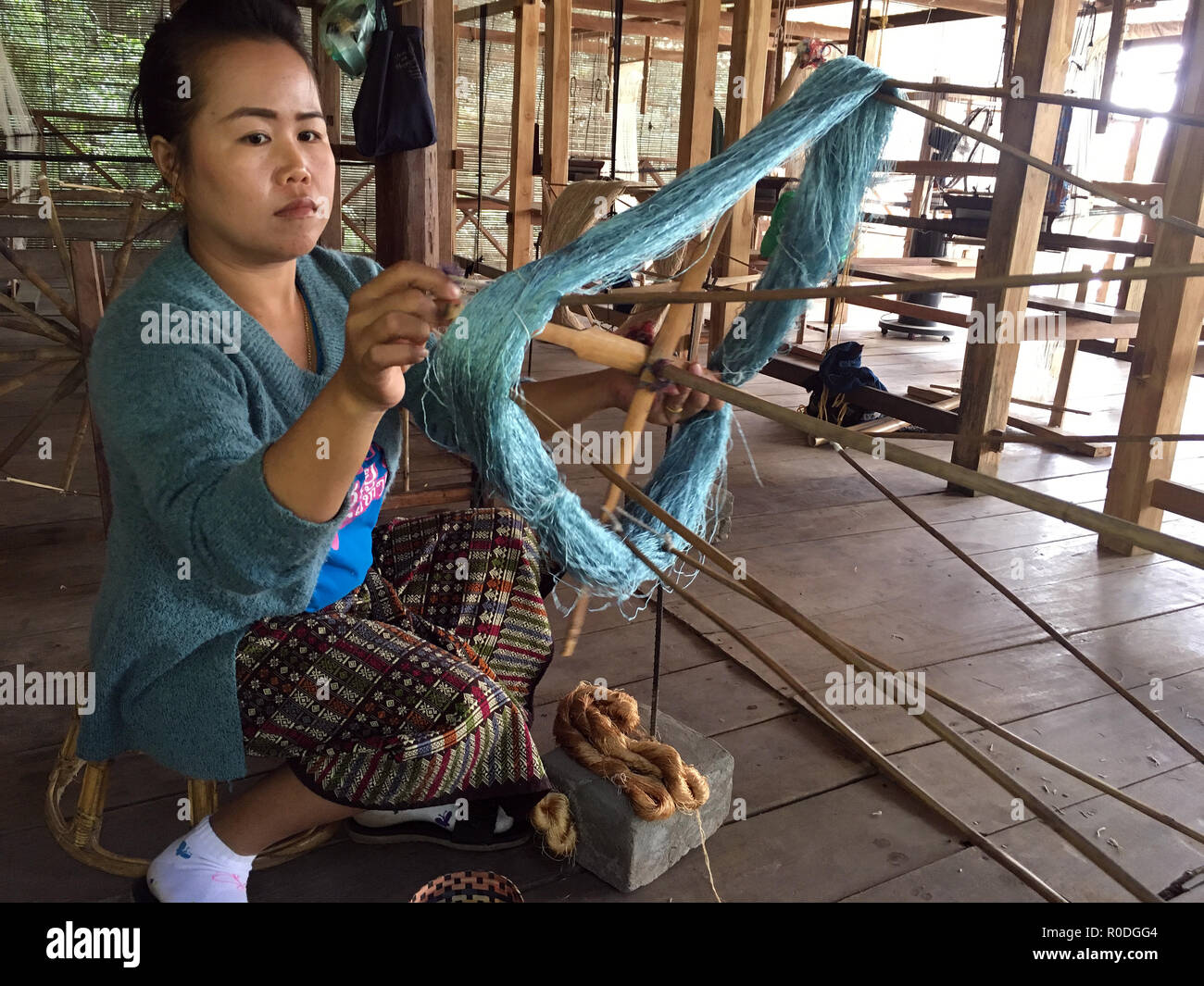Avvolgimento di una risma di seta in matasse a Ok Pop Tok centro di tessitura, Luang Prabang, Laos Foto Stock
