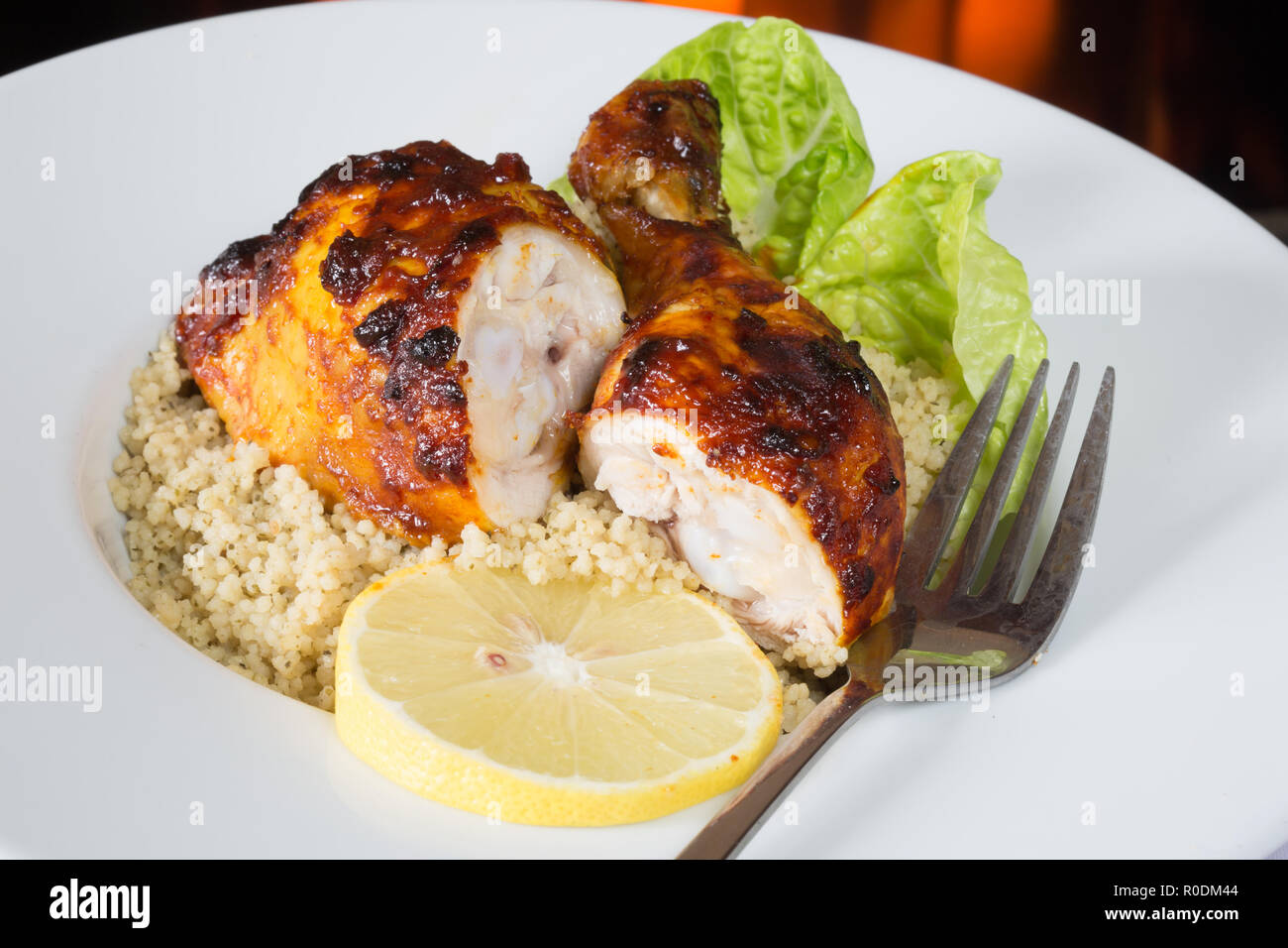 Jamaican jerk barbecue in stile le cosce di pollo con limone e coriandolo cous cous Foto Stock