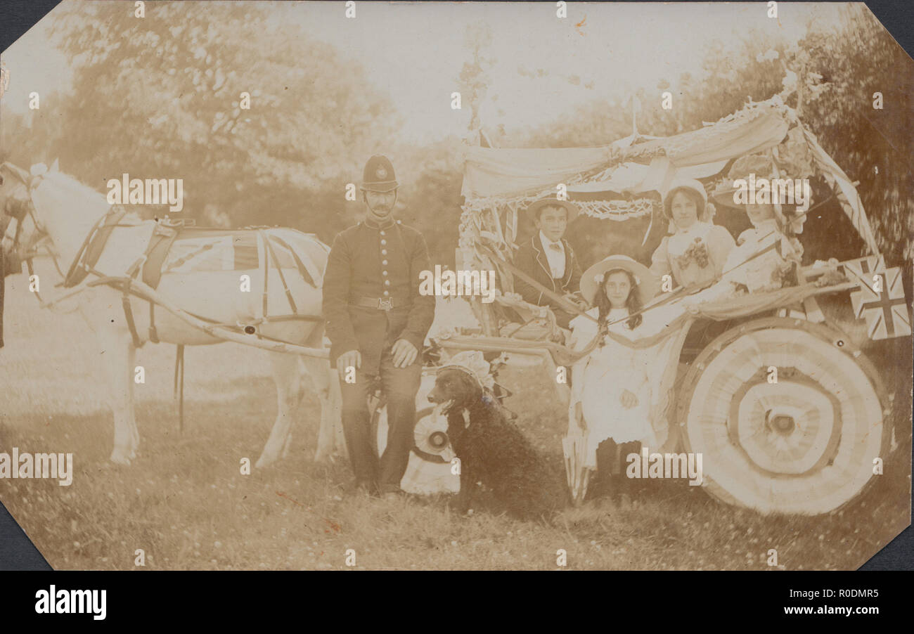 Vintage Cartolina fotografica di un poliziotto, un cane, e la gente seduta all'interno un decorato Cavallo Carnevale galleggiante. Foto Stock