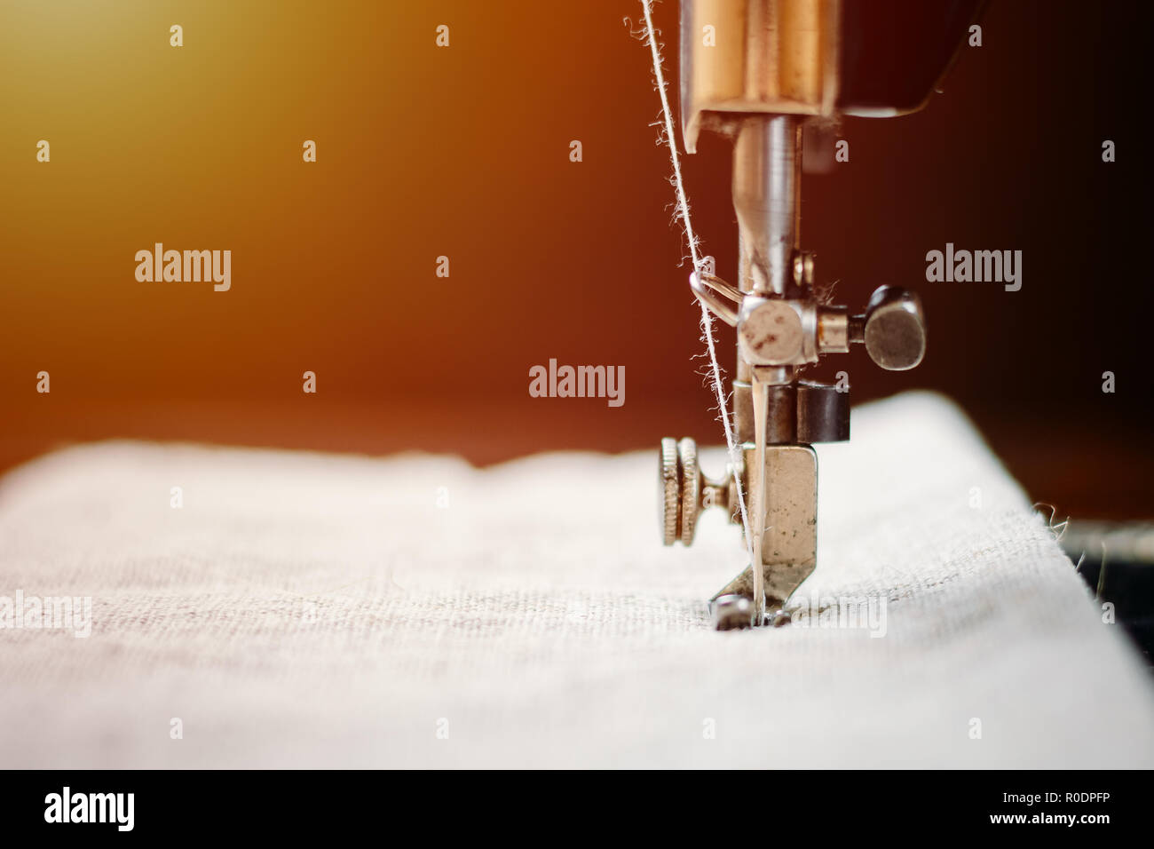 Parte della mano vintage macchina da cucire e capo di abbigliamento. Ago in acciaio con crochet e il piedino di close-up. Foto Stock