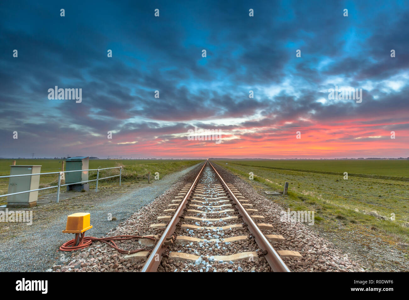 Infinite ferrovia sull'orizzonte sotto un rosso e blu cielo come un concetto per la futura carriera. Foto Stock