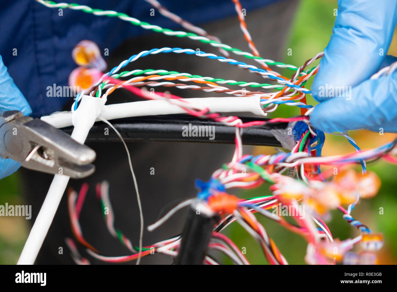 Fibra ottica, i tecnici sono installare mobile su un cavo a fibra ottica. La sfocatura delle immagini con retro illuminazione. Foto Stock