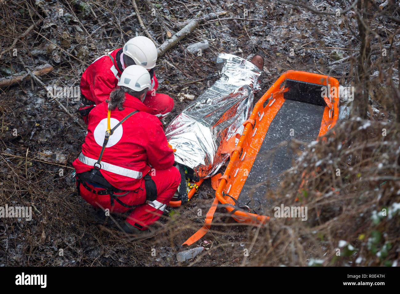 I paramedici da mountain rescue service fornire un primo aiuto durante un allenamento per il salvataggio di una persona in un incidente nella foresta. Irriconoscibile la gente. Foto Stock