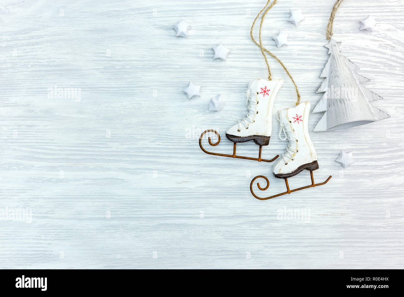 In legno rustico sfondo con decorazioni natalizie: piccoli pattini da ghiaccio, stelle abete Foto Stock
