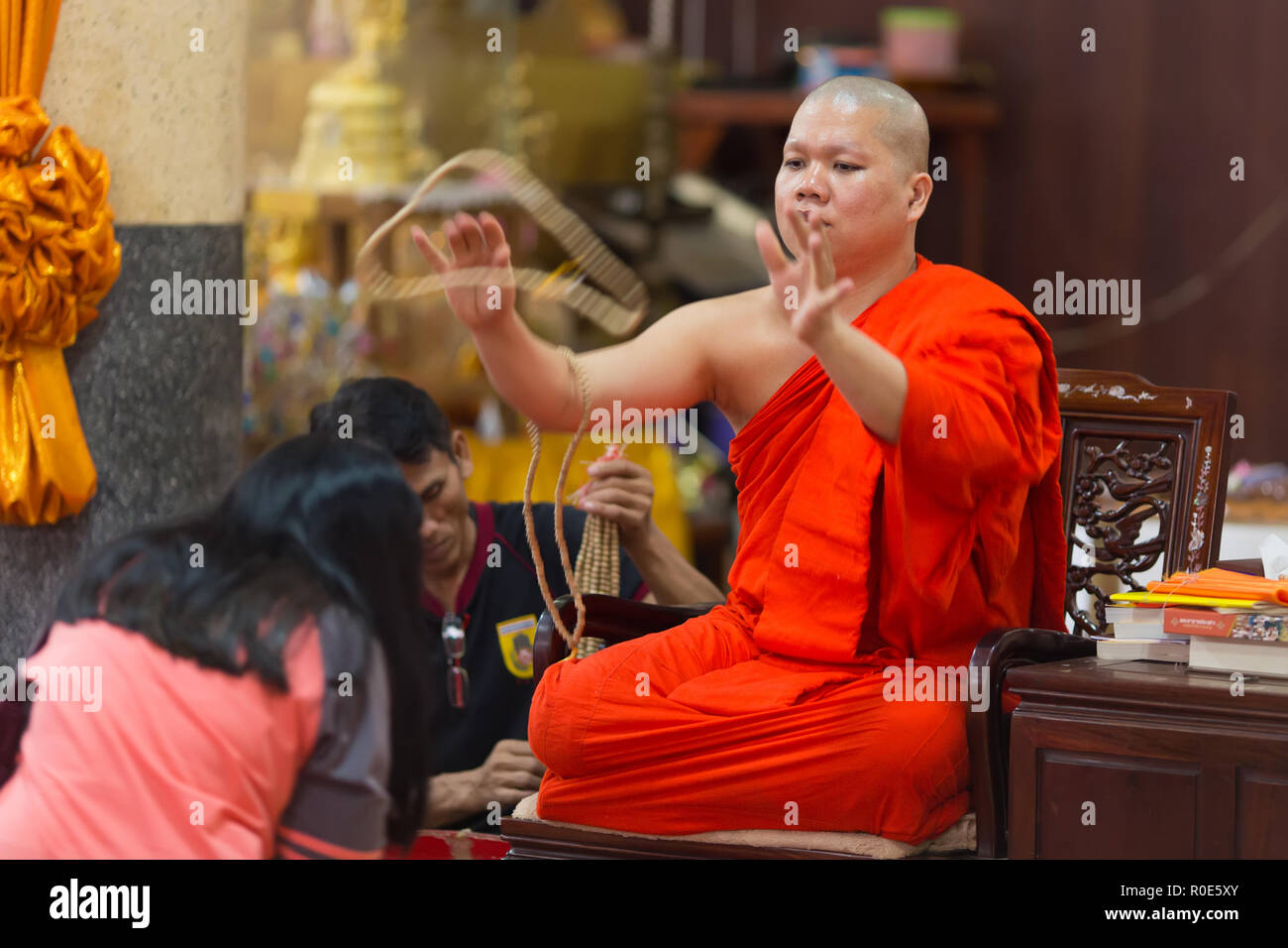 SANGKHLABURI, Thailandia, 24 gennaio 2016 : un esperto monaco buddista è la benedizione di una donna lanciando un rosario collana intorno al suo collo in Wat Wang W Foto Stock