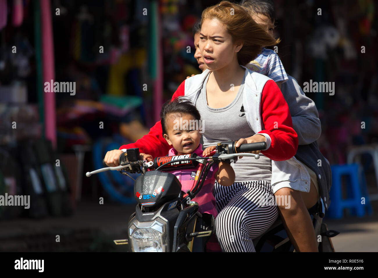 THONG PHA PHUM, Thailandia, 23 gennaio 2016 : Tre adulti e un bambino sono a cavallo di uno scooter senza casco di protezione in strada di Thong Pha Phum, Foto Stock