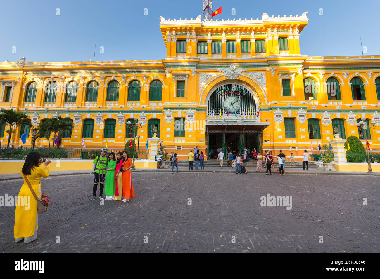 HO CHI MINH, Vietnam, 25 Febbraio 2015 : ampia vista sulla centrale di stile coloniale Francese post office con ragazze vietnamita in tradizionale Ao Dai dre Foto Stock