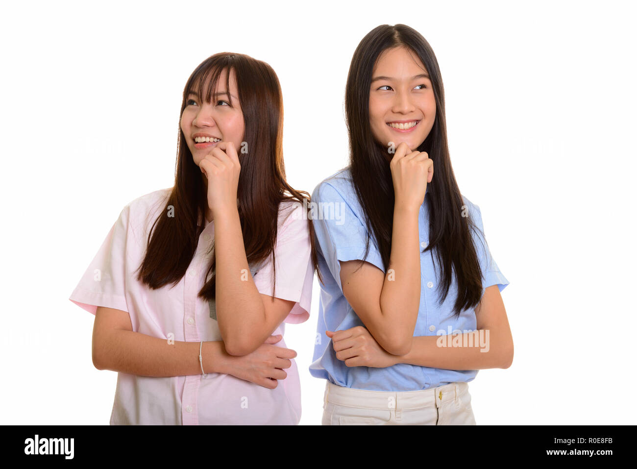 Due giovani felici Asian ragazze adolescenti sorridente e pensando togethe Foto Stock