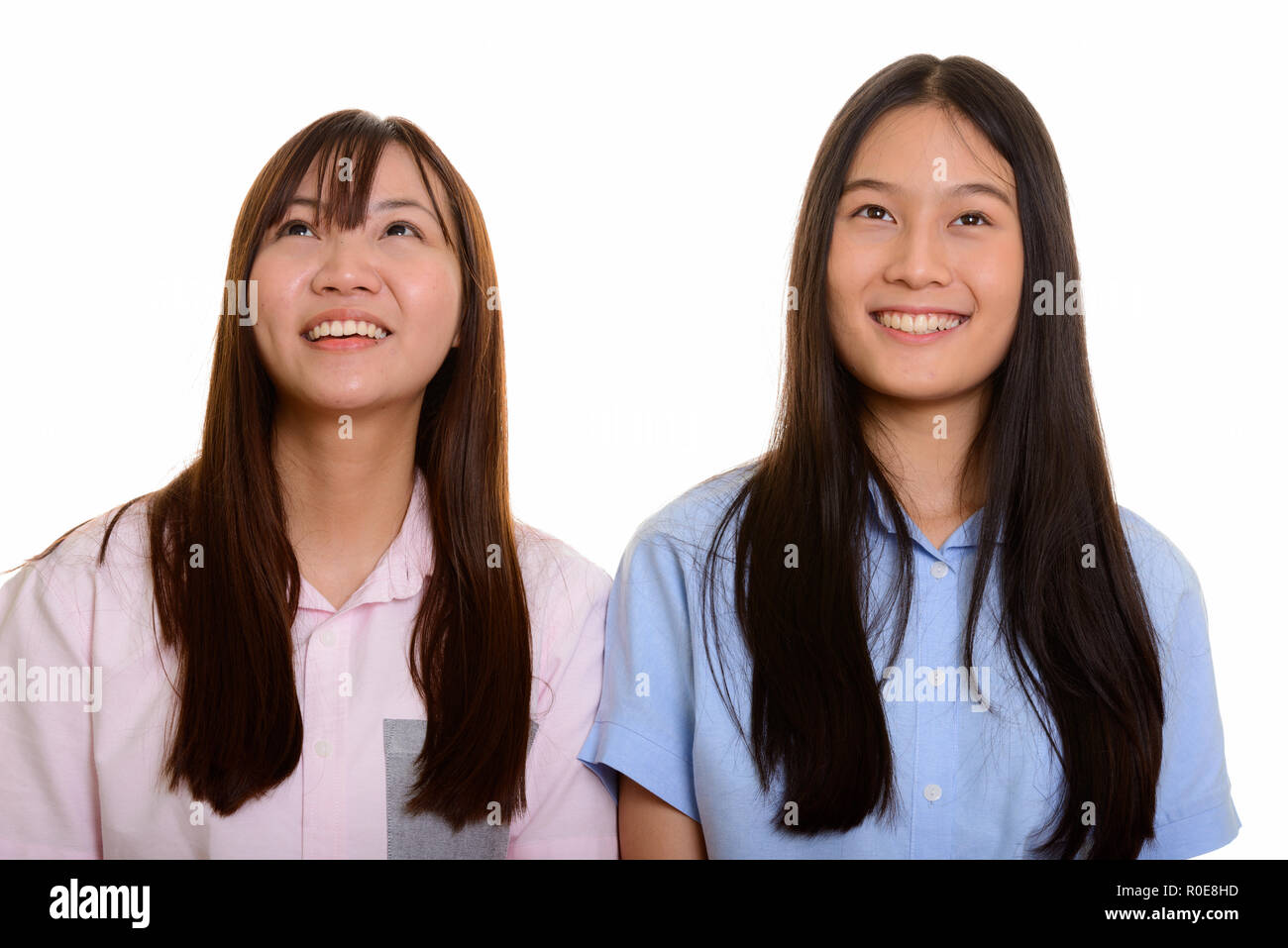 Due giovani felici Asian ragazze adolescenti sorridente e pensare Foto Stock
