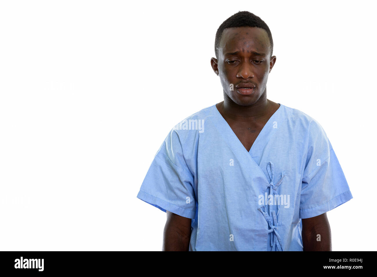 Studio shot del giovane africano nero uomo paziente cercando stanco Foto Stock