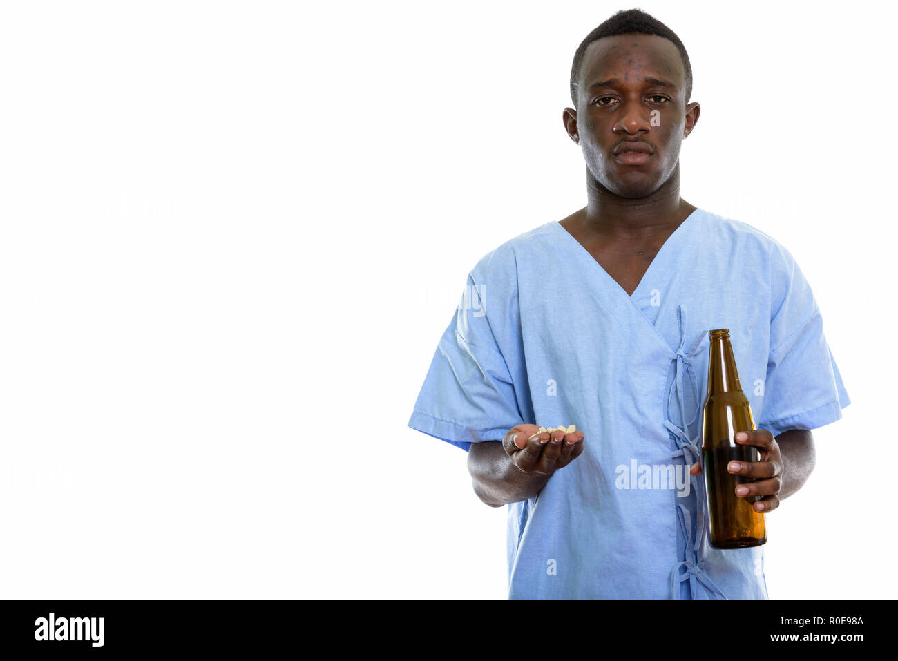 Studio shot del giovane africano nero uomo paziente tenendo la vitamina t Foto Stock
