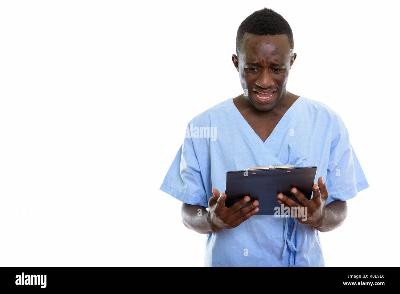 Studio shot del Giovane triste Africano nero uomo paziente sulla lettura cl Foto Stock