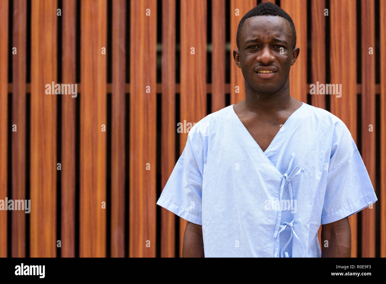 Studio shot di giovani neri africani paziente uomo contro di legno ga Foto Stock