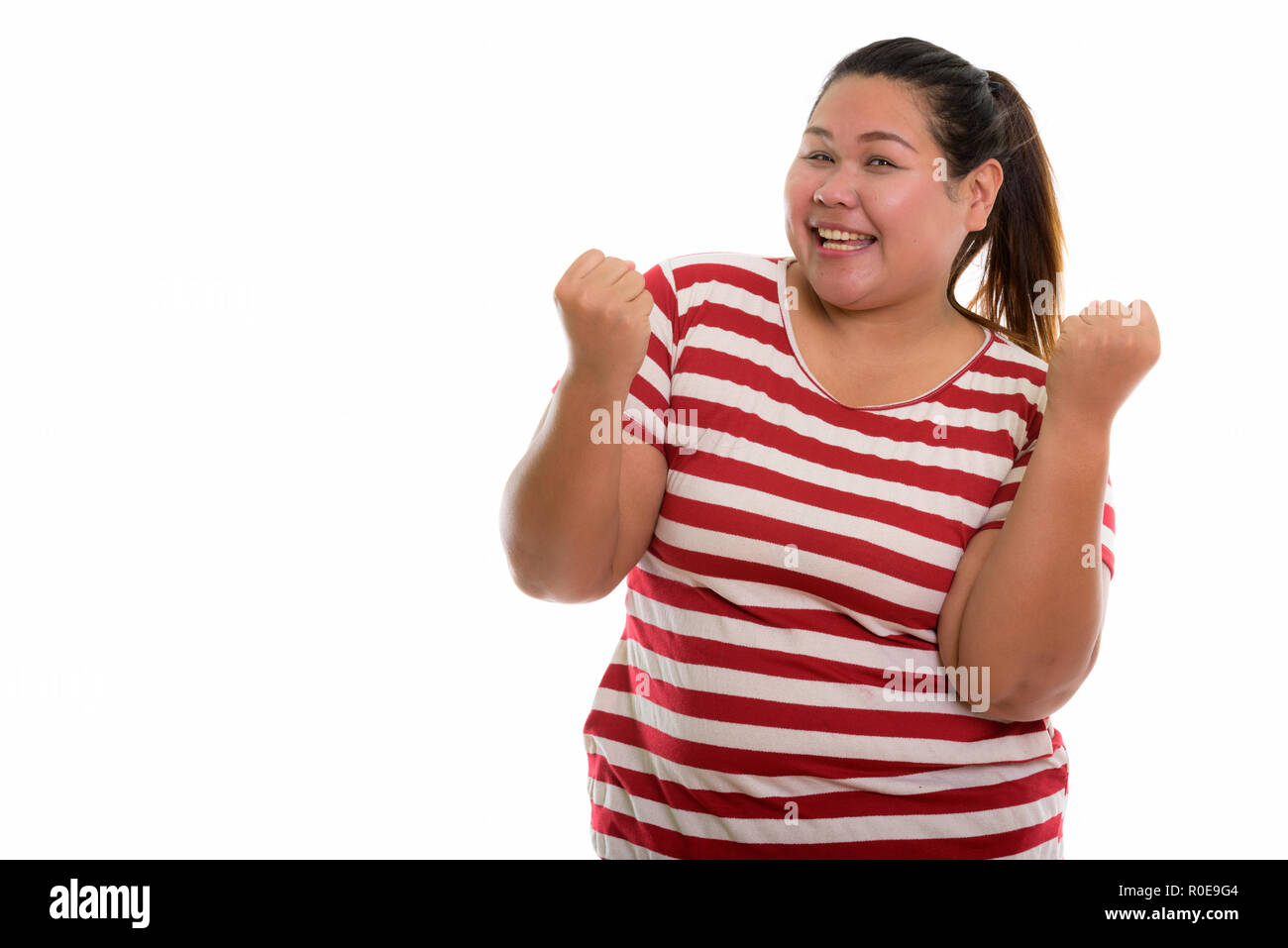 Studio shot di giovani felici fat donna asiatica sorridente e cercando di e Foto Stock