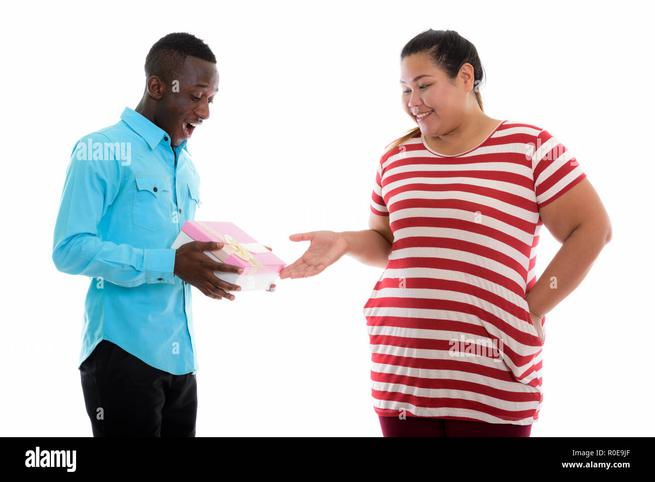 Il grasso donna asiatica dando confezione regalo al giovane nero africano Foto Stock