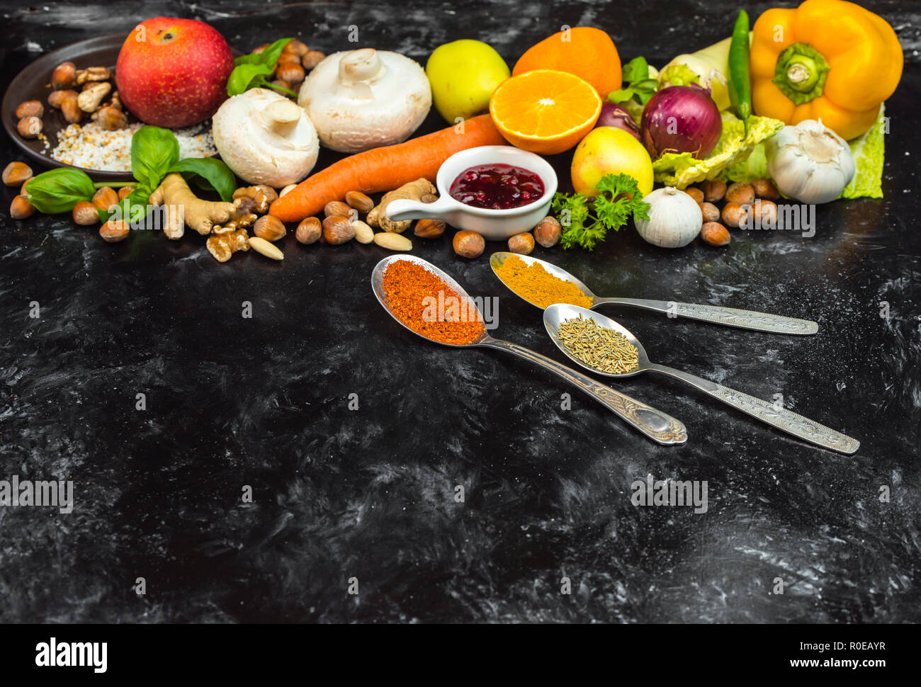 Colorata, sana le erbe aromatiche, le spezie e la frutta e le verdure sul nero, tavolo di pietra Foto Stock