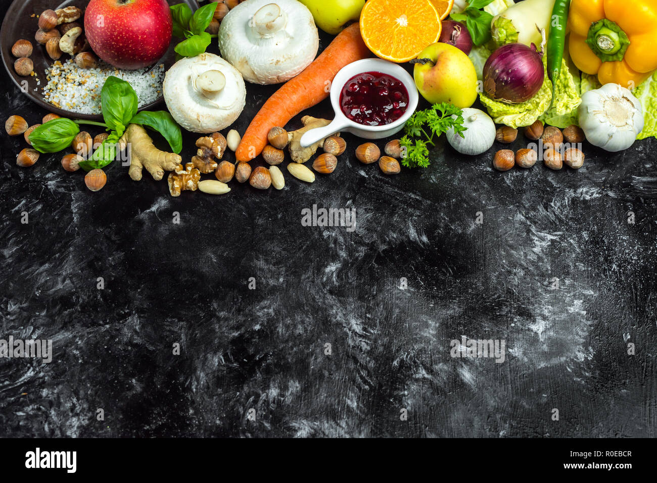Colorata, sana le erbe aromatiche, le spezie e la frutta e le verdure sul nero, tavolo di pietra Foto Stock