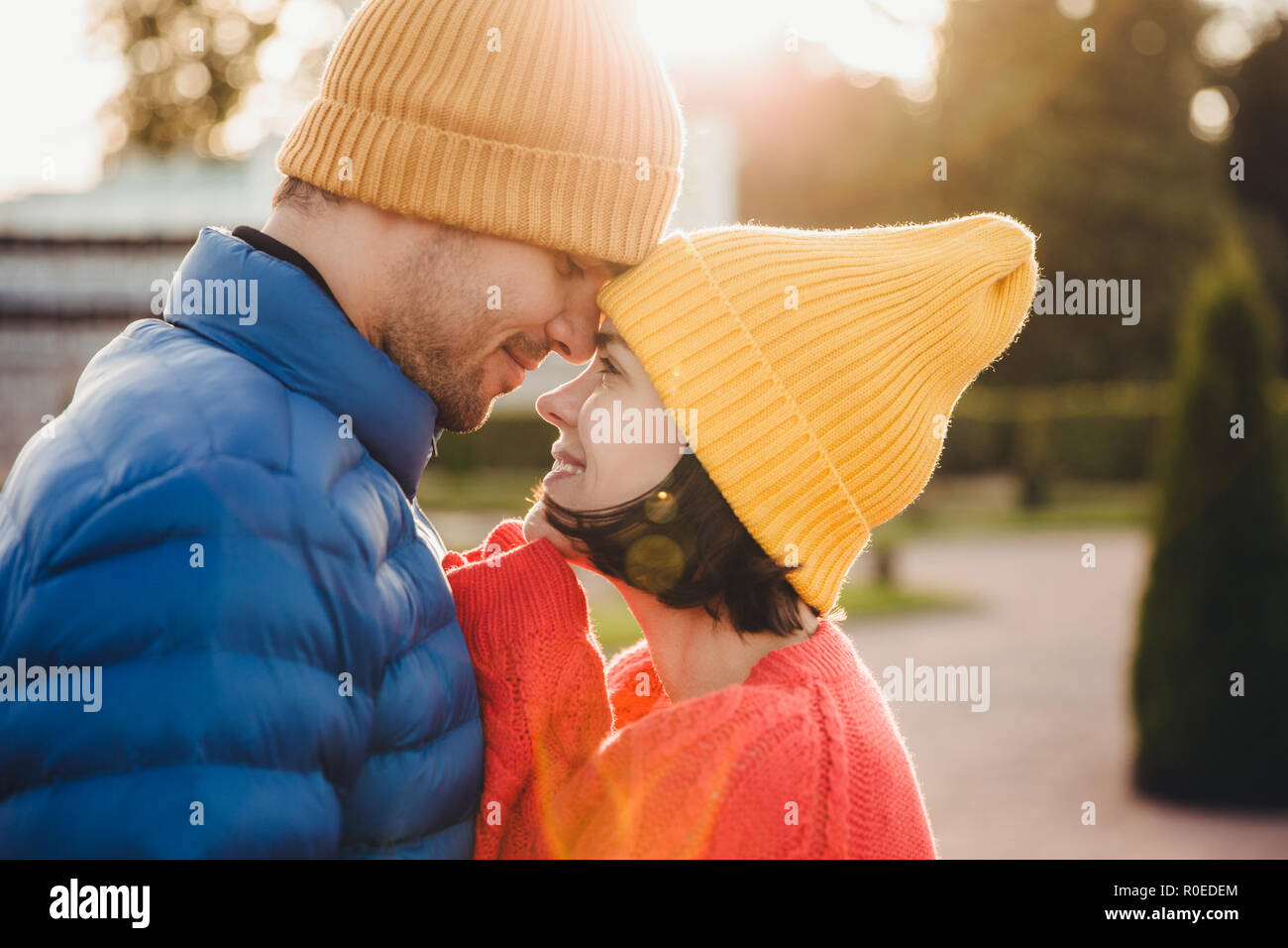 Romantico coppia giovane guardiamo con grande amore, hanno una bella relazione, a baciare, hanno a piedi all'aperto nel parco, indossare abiti caldi. Incantevole Foto Stock