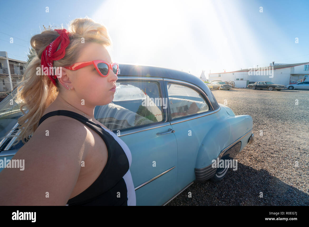 Bionda femmina adulta con un degli anni cinquanta vintage pin up  acconciatura sorge nelle vicinanze di un abbandono auto d'epoca, indossando  occhio di gatto occhiali da sole Foto stock - Alamy
