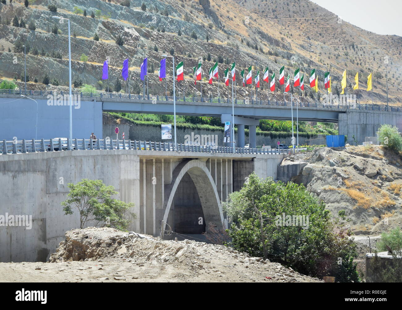 Grande arcata ponte concreto di una autostrada in Iran collegando le vicine città di Teheran e Karaj decorate con decine di bandiere iraniano Foto Stock