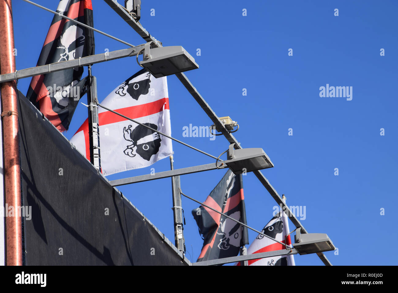 CASTELSARDO, Italia - 12 settembre 2018: un sacco di bandiere del nazionalismo sardo di fronte blu profondo e cielo chiaro in estate sarda sventolando bandiere Foto Stock