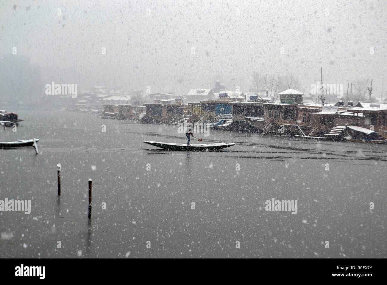 La questione del Kashmir, India. 4 Nov 2018. Un uomo visto il canottaggio la sua barca su Dal lago durante la prima stagione di nevicata.diritto all'avvento dell'inverno, Kashmir valley ha ricevuto la sua prima nevicata come ondata di freddo come le condizioni afferrata la valle a causa di continue acquazzone. Tutte le stazioni meteorologiche attraverso la valle assistito ad un calo di circa 10 gradi Celsius dalle normali temperature di giorno per questo periodo dell'anno. Credito: Saqib Majeed SOPA/images/ZUMA filo/Alamy Live News Foto Stock