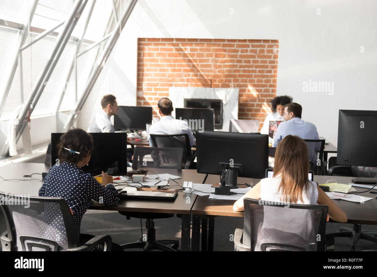 Ufficio dei lavoratori che utilizzano computer che lavorano presso i moderni grande spazio aperto Foto Stock
