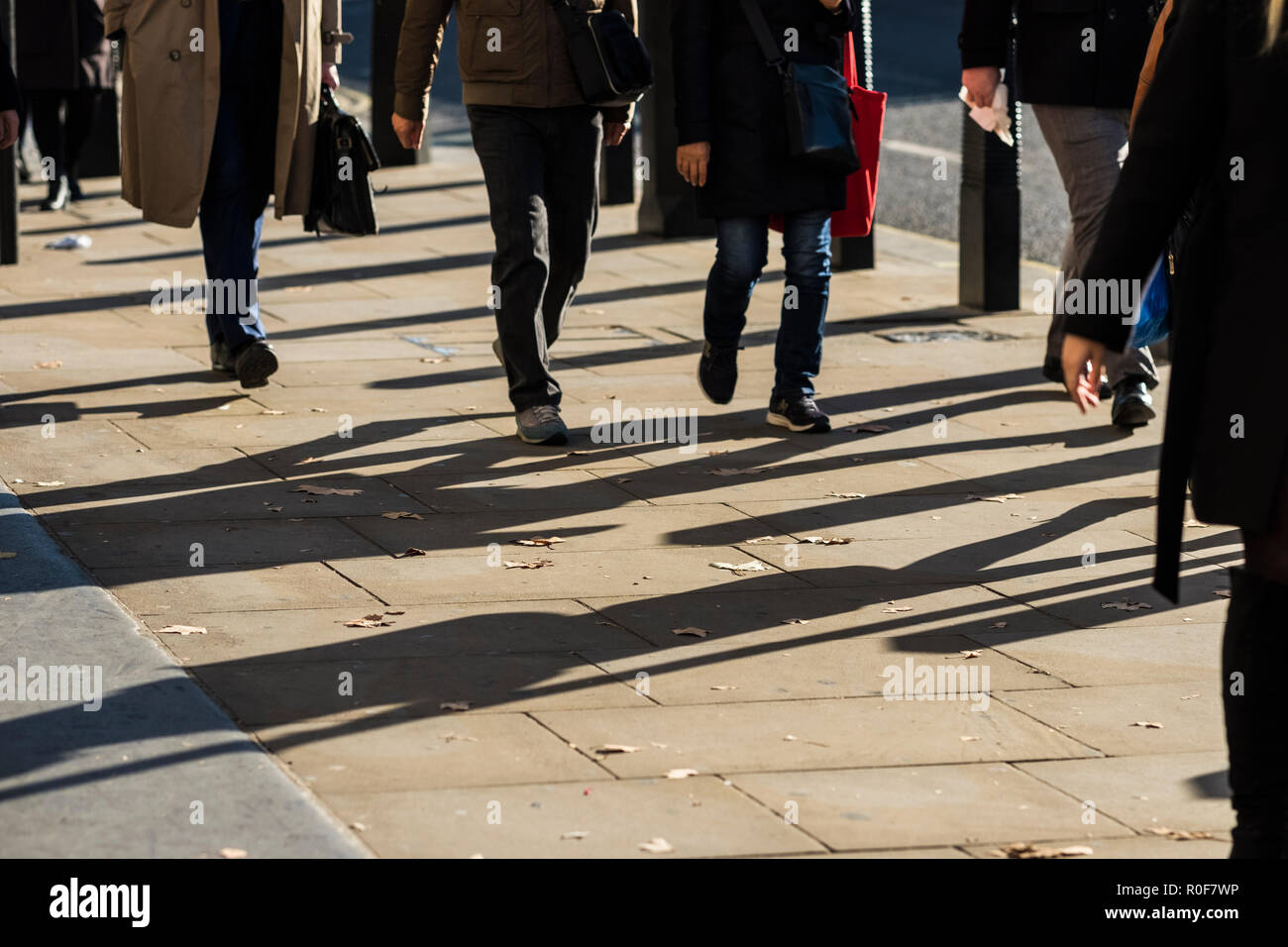 La gente le ombre proiettate sul marciapiede, Westminster, London, England, Regno Unito Foto Stock