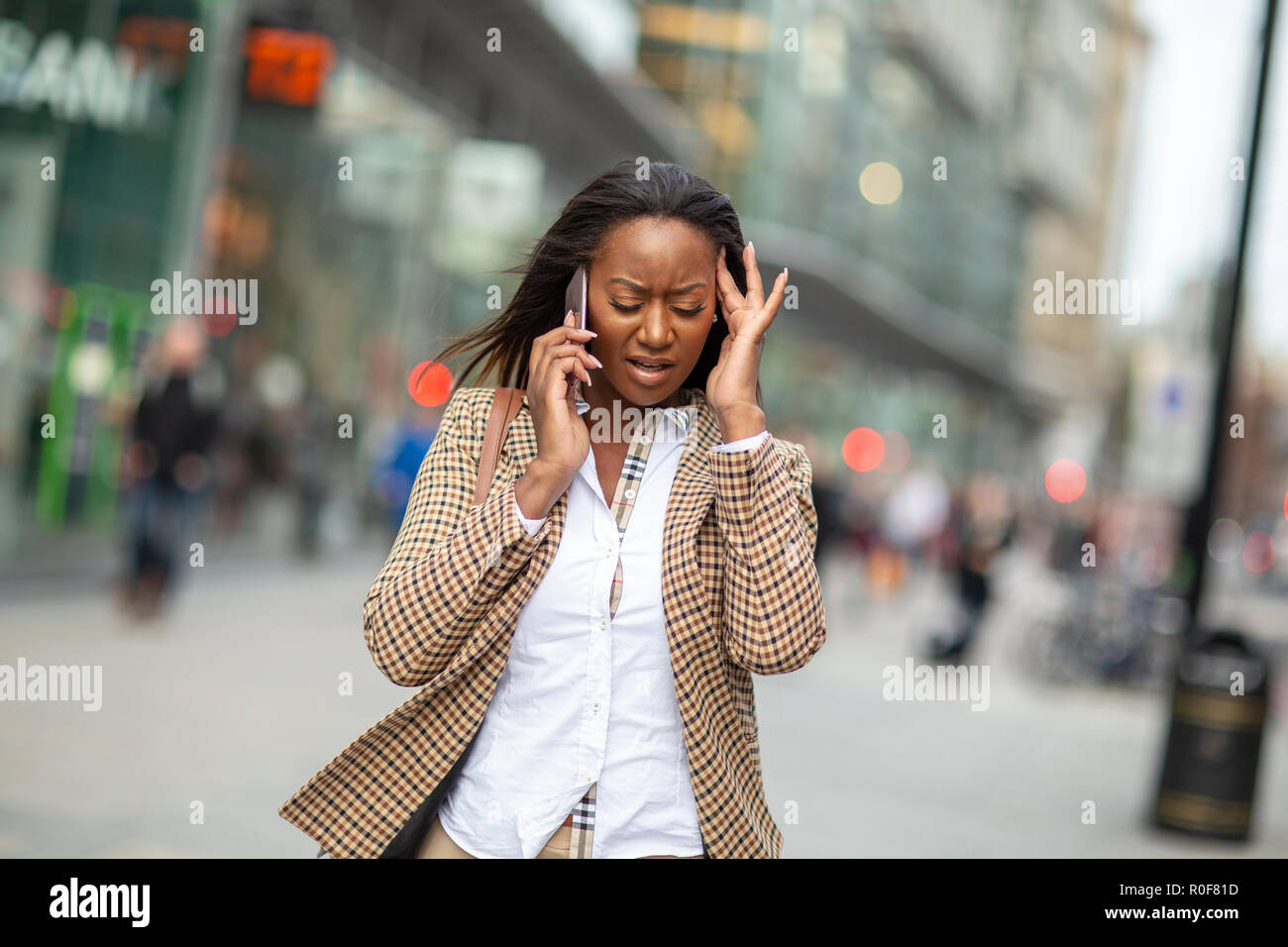 Giovane donna di affari al telefono di fronte a una situazione difficile. Foto Stock